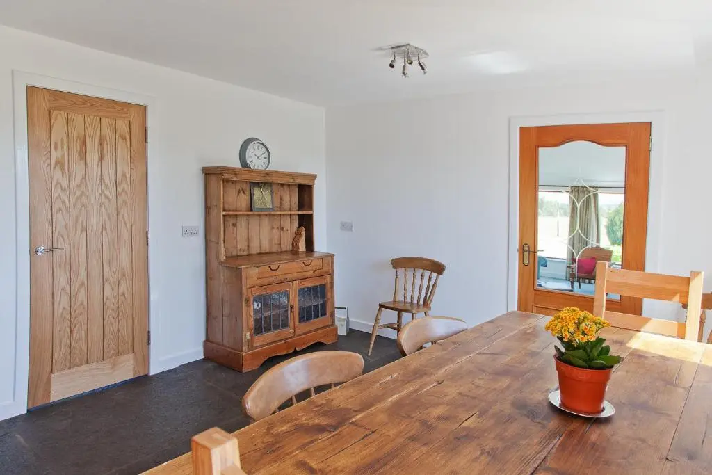 a dining room with a wooden table and chairs at Belforte House Holiday Home in Inverness