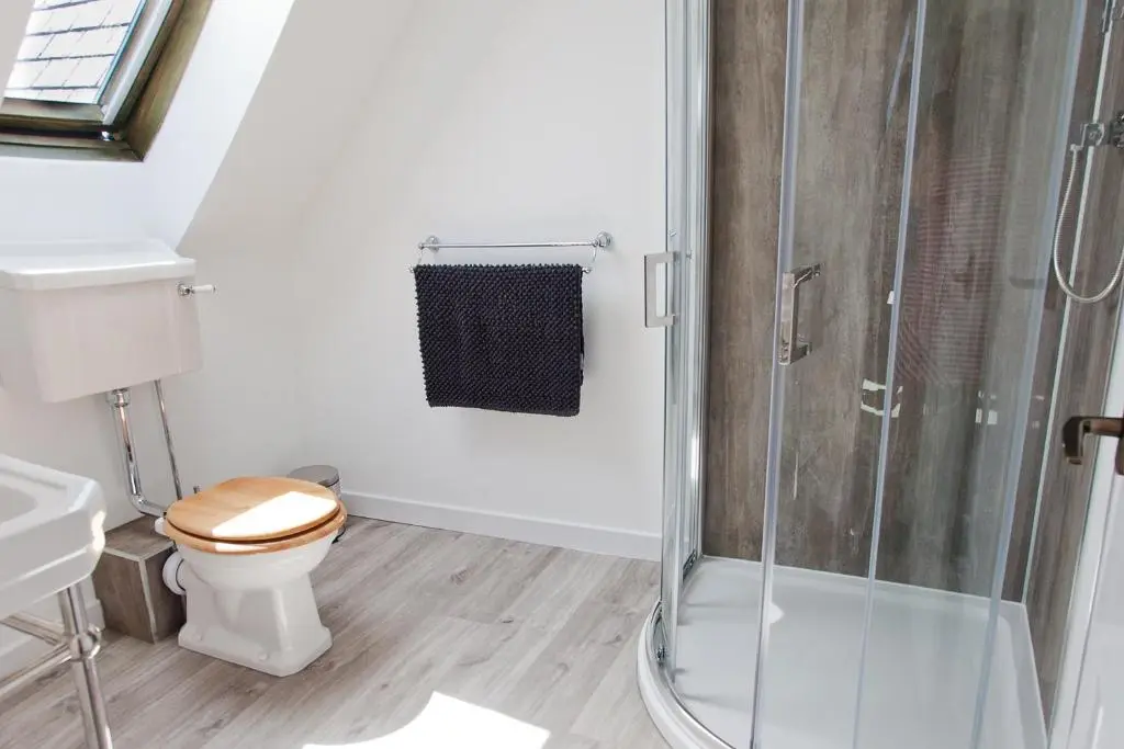a bathroom with a toilet and a glass shower at Belforte House Holiday Home in Inverness