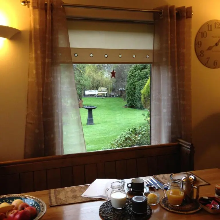 a table with a view of a garden through a window at Old Mills Garden in Elgin