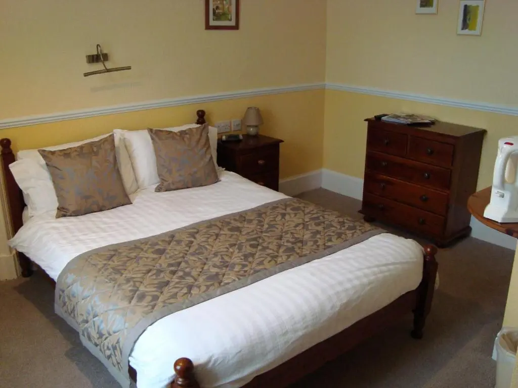 a bedroom with a bed and a wooden dresser at Willowbank in Grantown on Spey