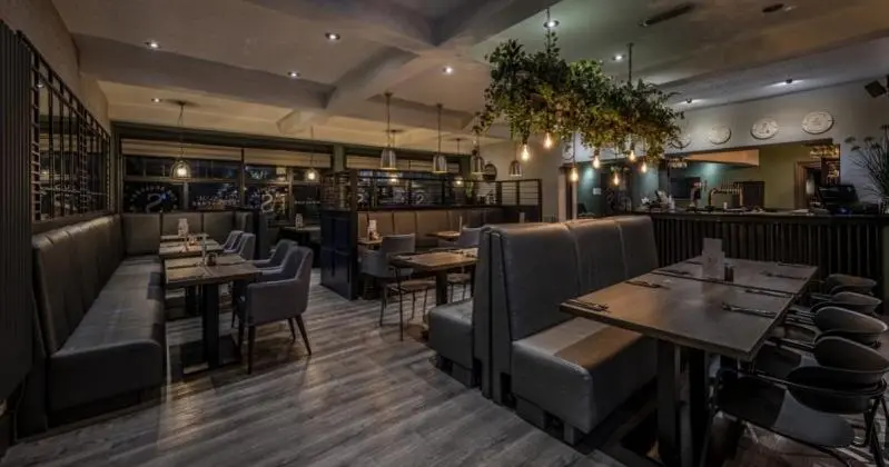 a restaurant with tables and chairs and a bar at Newmachar Hotel in Newmachar