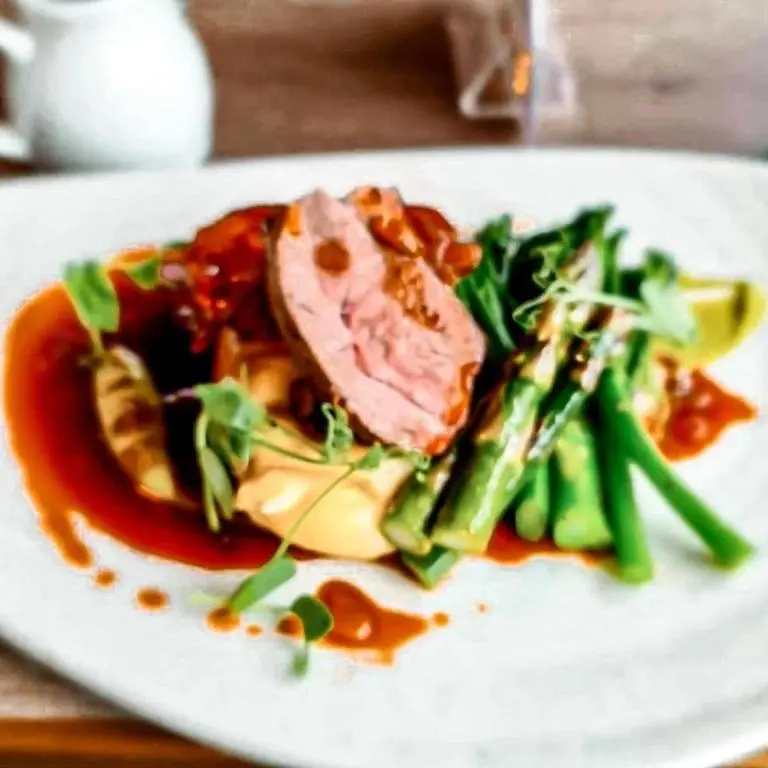 a plate of food with meat and vegetables on a table at Newmachar Hotel in Newmachar