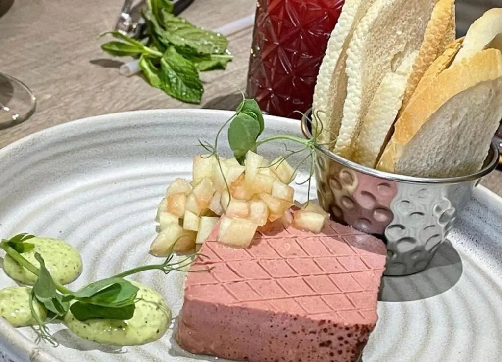 a plate with a piece of cake and bread on it at Newmachar Hotel in Newmachar