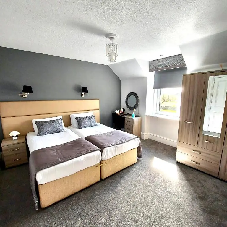 a bedroom with a large bed and a window at Newmachar Hotel in Newmachar