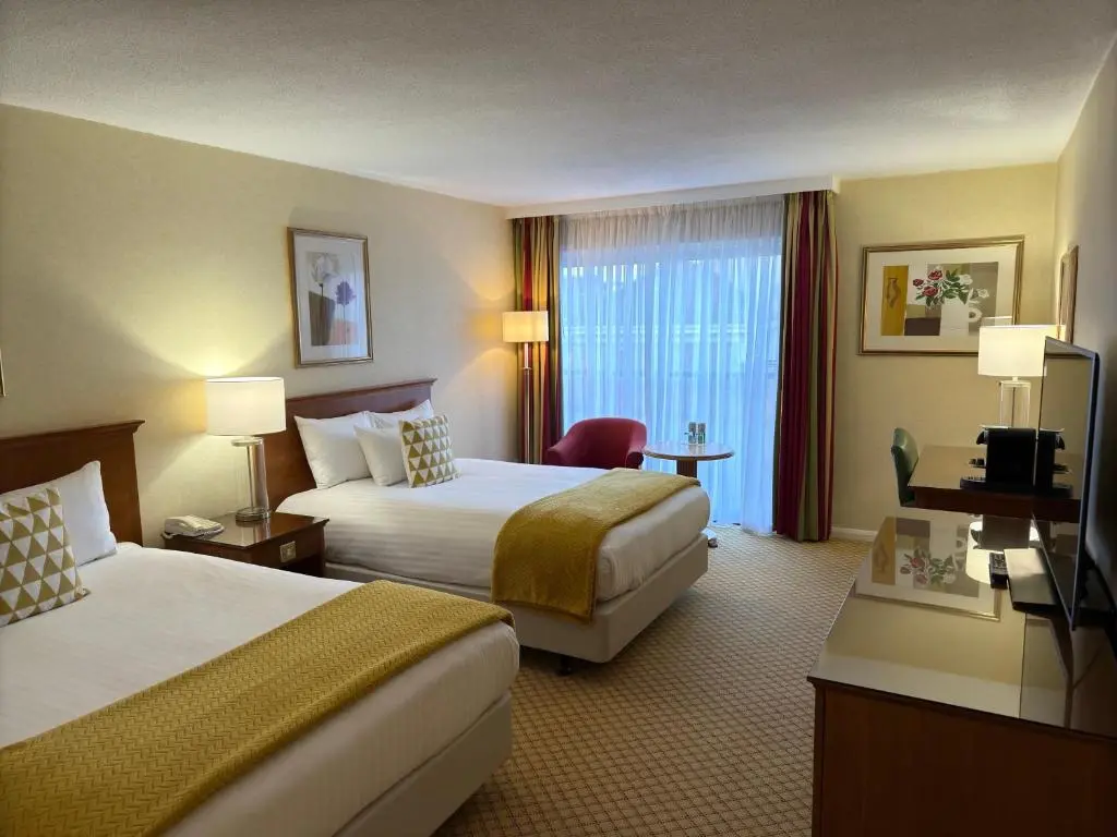 a hotel room with two beds and a television at The Aberdeen Dyce Hotel in Dyce