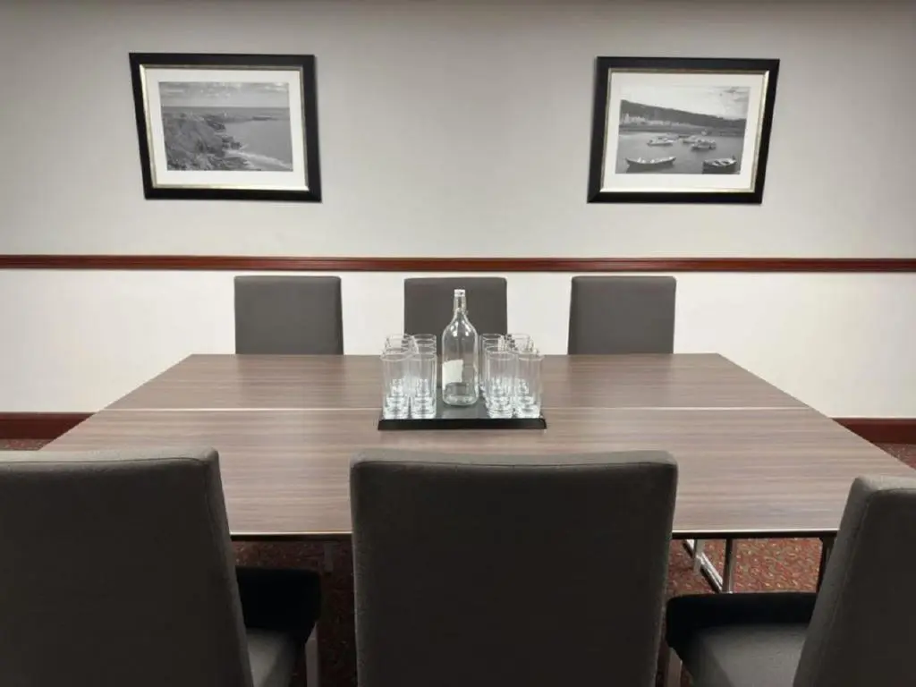 a wooden table with a bottle and glasses on it at The Aberdeen Dyce Hotel in Dyce