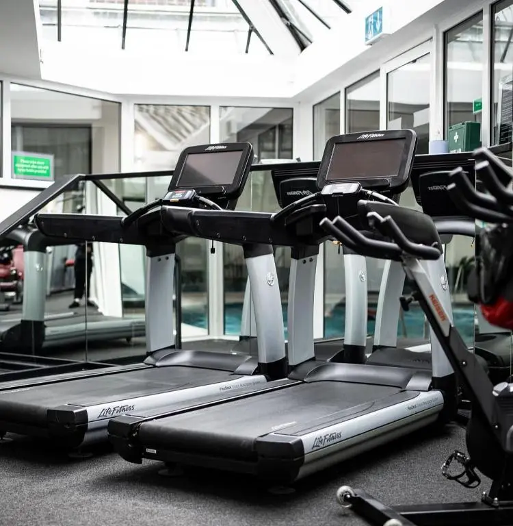 a gym with two cardio bikes in a building at The Aberdeen Dyce Hotel in Dyce