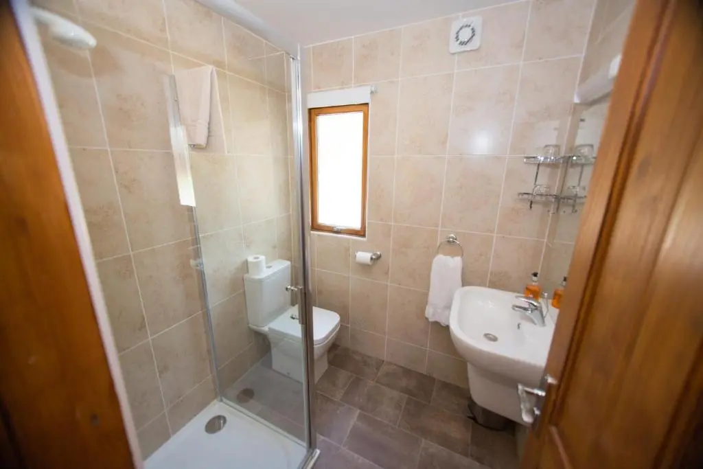 a bathroom with a shower and a toilet and a sink at Invercauld Lodges in Ballater