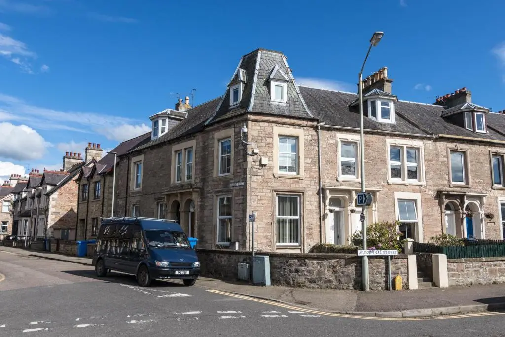 a blue van parked in front of a brick building at The Nessting Place in Inverness