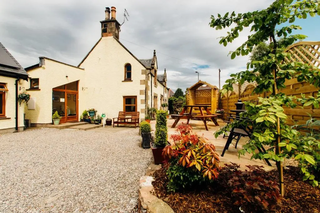 a courtyard of a house with a garden at Furan GuestHouse in Inverness