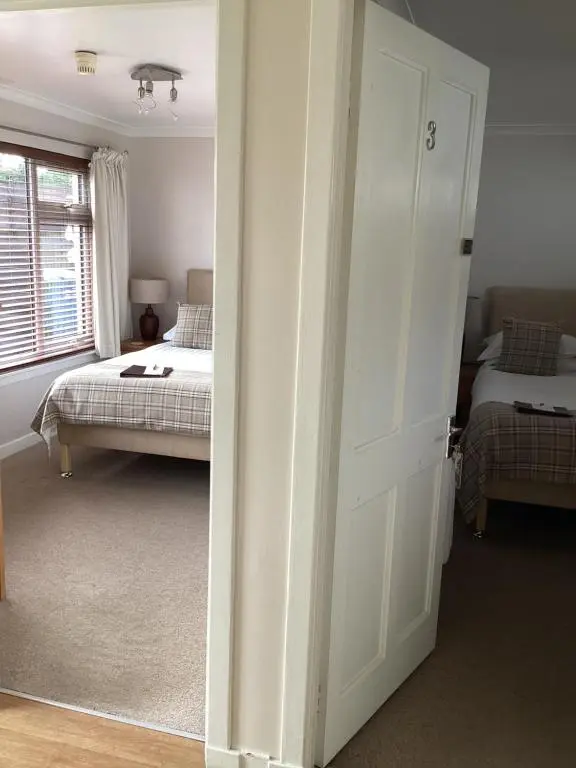an open door to a bedroom with two beds at Furan GuestHouse in Inverness