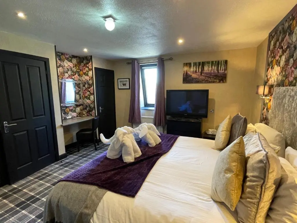 a bedroom with a bed with two elephants on it at The Albert Inn in Nairn