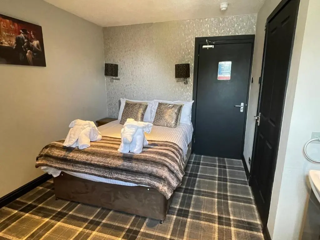 a bedroom with a bed with towels on it at The Albert Inn in Nairn