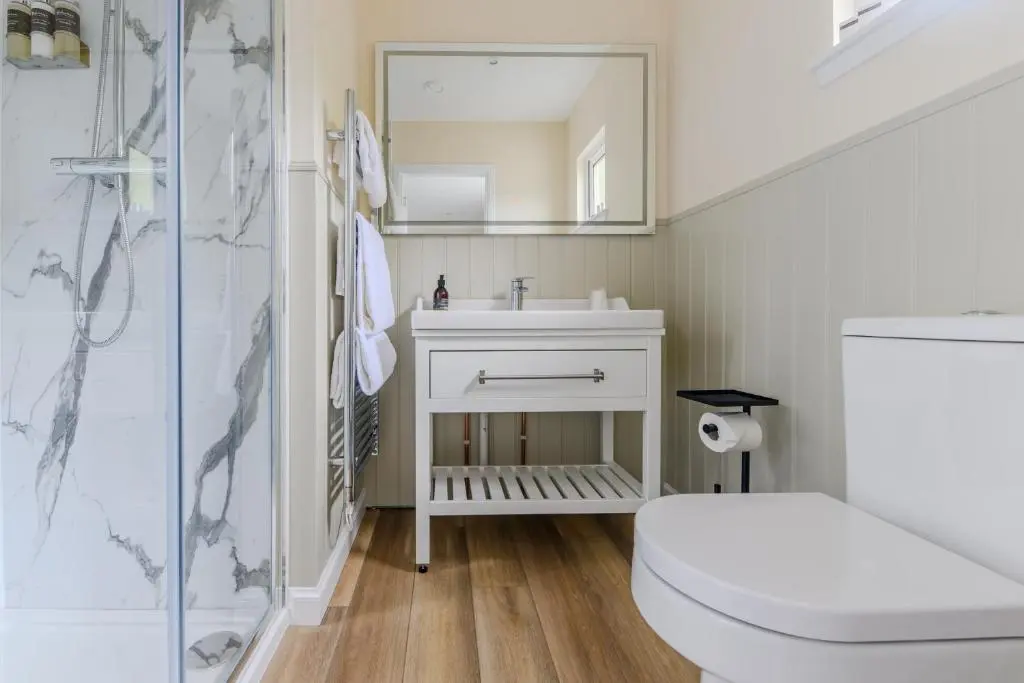 a bathroom with a sink and a toilet and a mirror at Loch Ness Clansman Hotel in Drumnadrochit