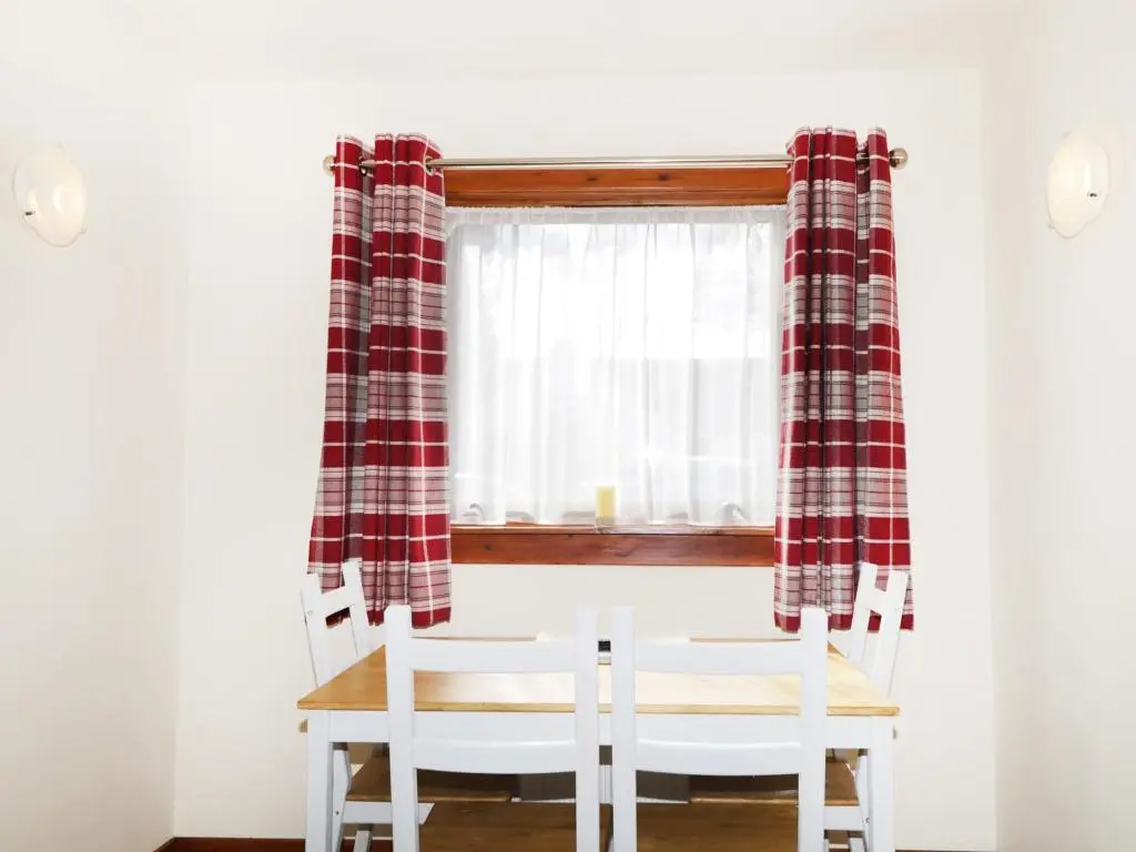 a dining room table and chairs in front of a window at Dalnahaven in Grantown on Spey