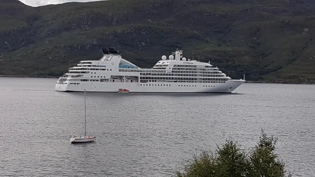 a large cruise ship in a body of water at Lochview Guest House in Ullapool