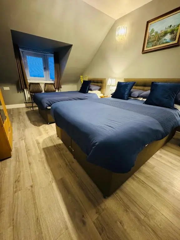 a bedroom with two beds with blue pillows at The Milton Accommodation in Elgin