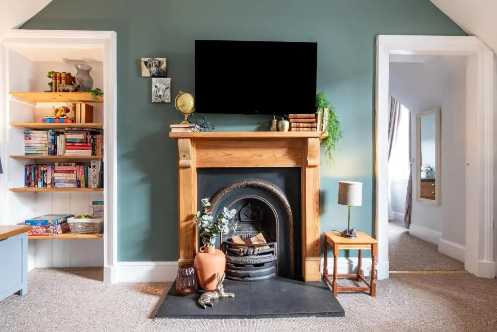 a living room with a fireplace with a tv above it at Taigh Carnan in Inverness