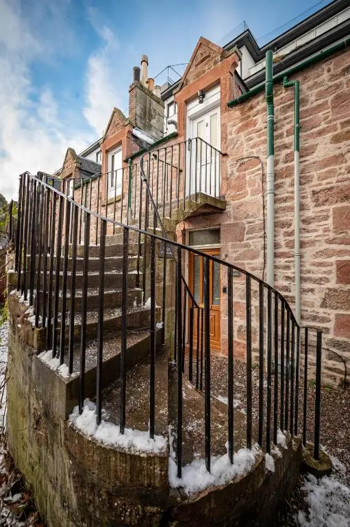 a fence in front of a house with snow at Taigh Carnan in Inverness