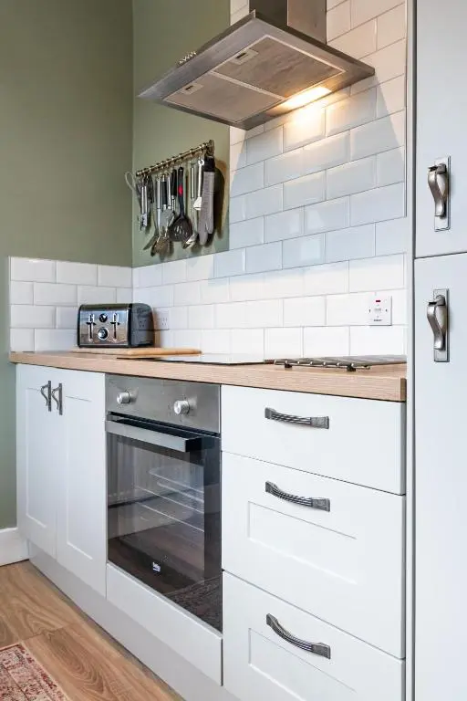 a kitchen with white cabinets and a stove at Taigh Carnan in Inverness