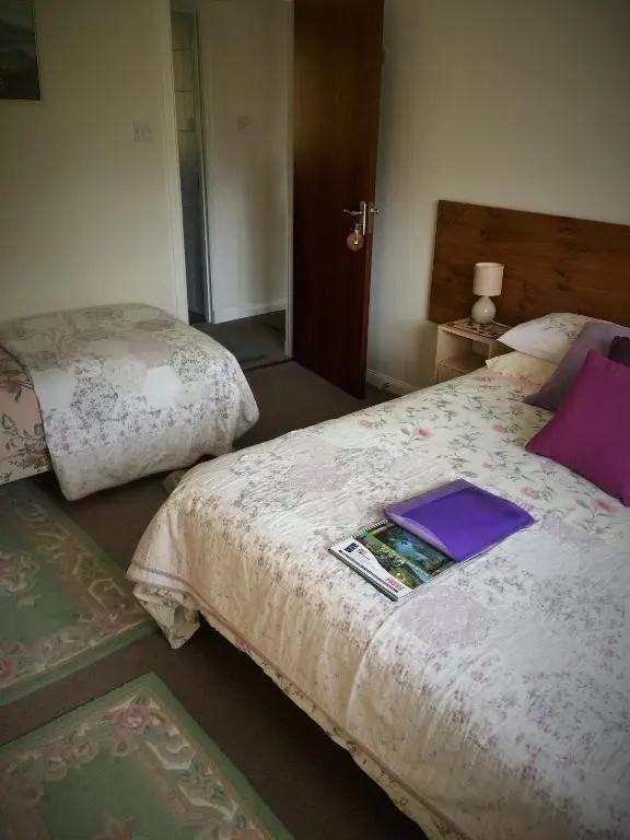 a bedroom with two beds with a book on it at Aslaich in Drumnadrochit