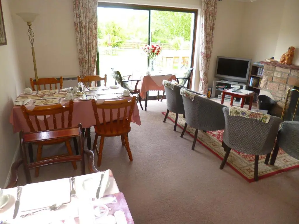 a dining room with a table and chairs and a television at Aslaich in Drumnadrochit