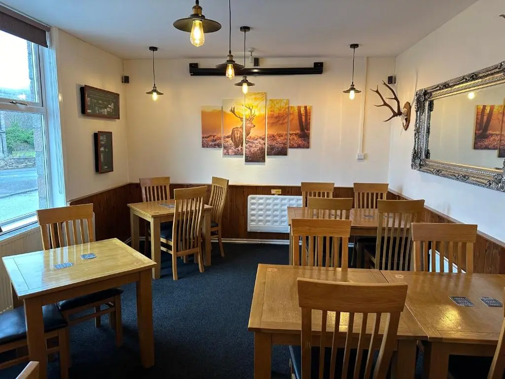 a dining room with wooden tables and chairs at The Glen Hotel Newtonmore - Rooms, bar & restaurant in Newtonmore