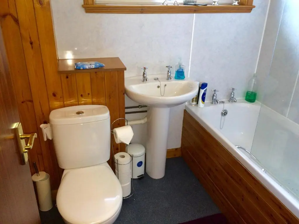 a bathroom with a toilet and a sink and a tub at Invermac House in Inverness