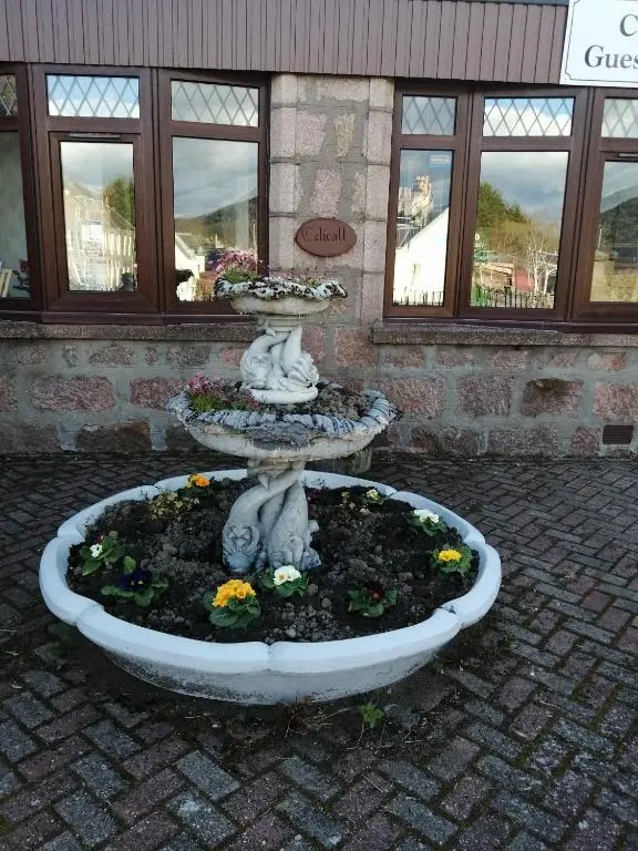 a fountain in a courtyard with flowers in it at Celicall in Ballater