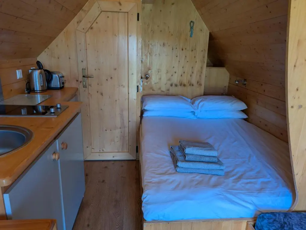 a small bed in a wooden room with a sink at Macbeth's Hillock in Forres