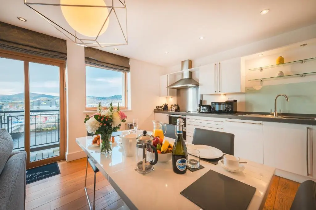 a kitchen with a dining table with a view at Highland Apartments by Mansley in Inverness