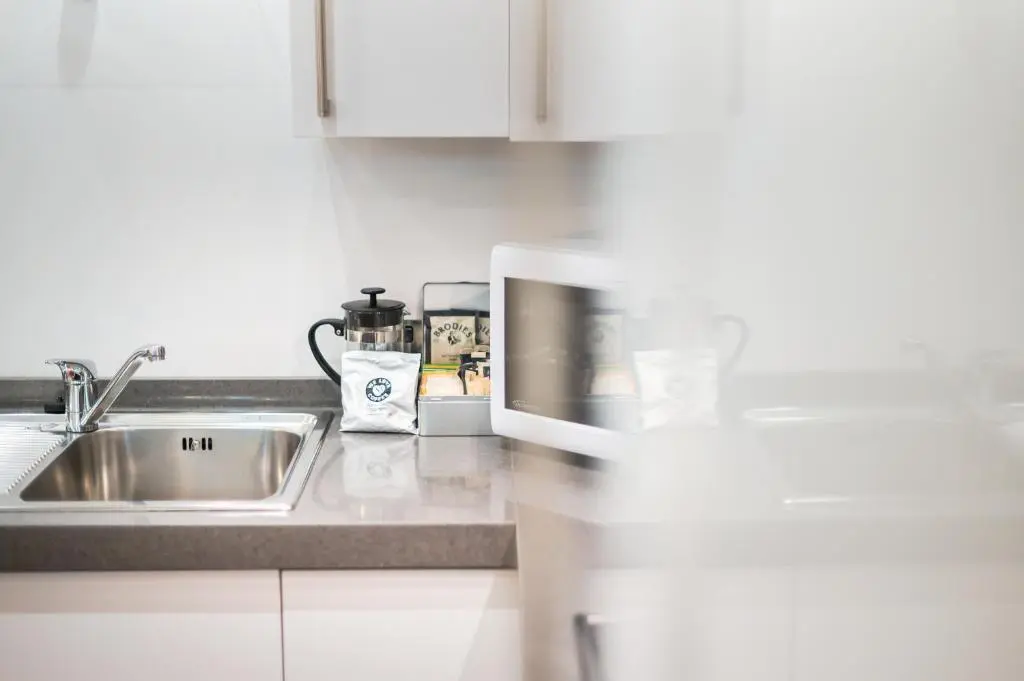 a kitchen with a sink and a microwave at Highland Apartments by Mansley in Inverness