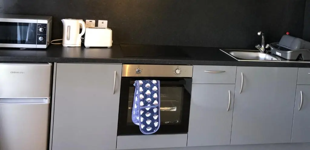 a oven with a blue and white tie hanging from it at Kilcoy Chalets in Muir of Ord