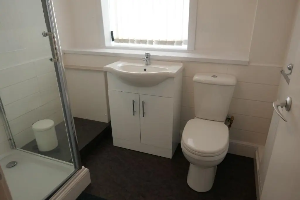 a bathroom with a toilet and a sink and a window at Inverness Family House in Inverness