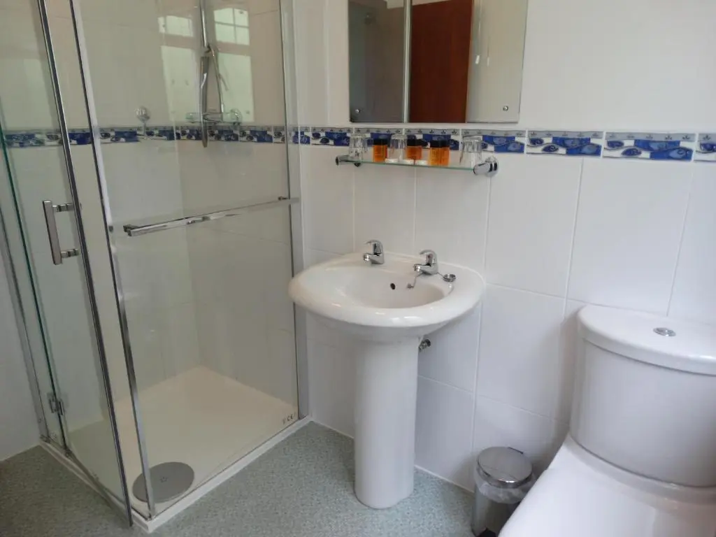 a bathroom with a sink and a shower and a toilet at Laggan Hotel in Laggan