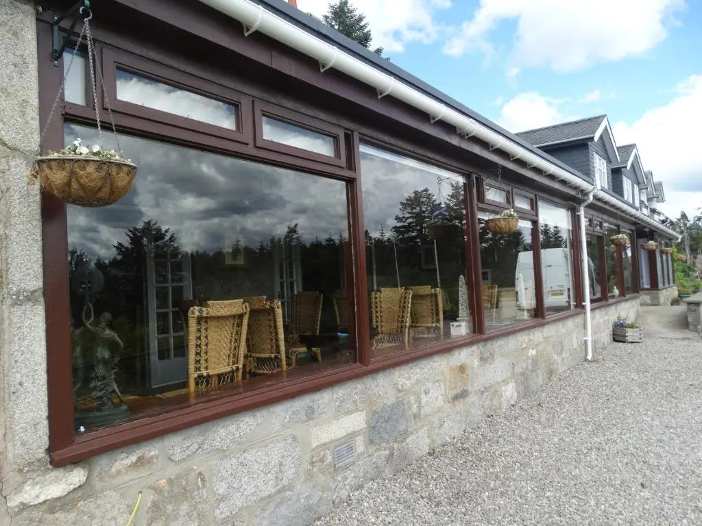 a store window with a reflection of a storm at Laggan Hotel in Laggan