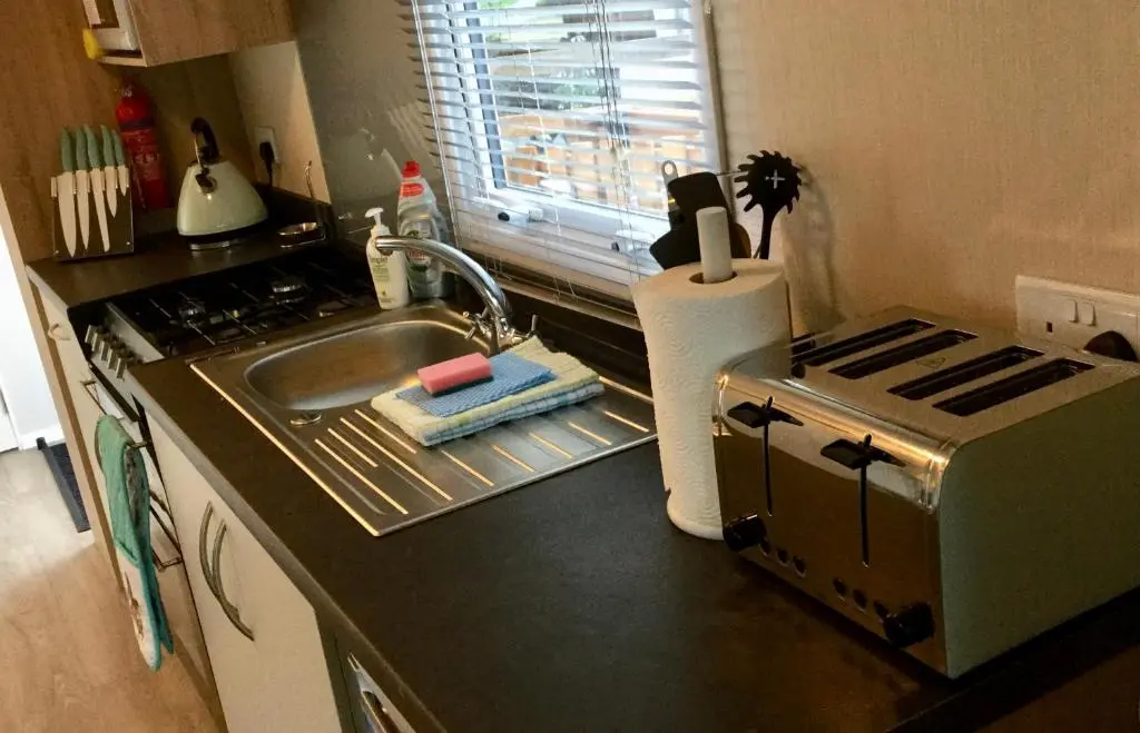 a kitchen with a sink and a toaster on the counter at Poppy Lodge in Boat of Garten