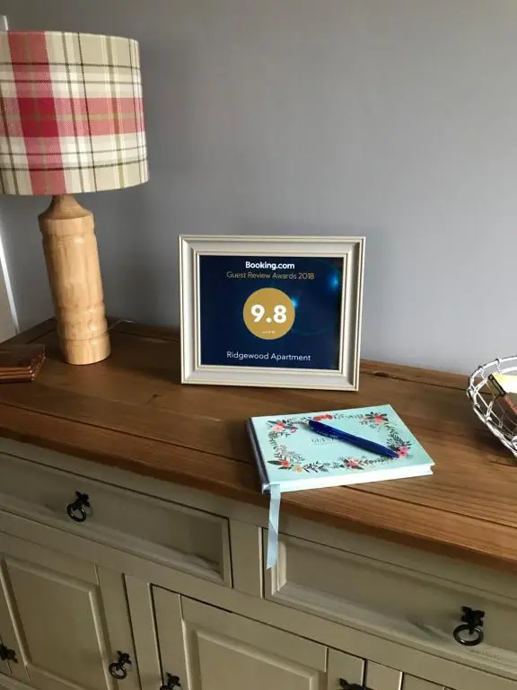 a table with a picture on top of a dresser at Ridgewood Apartment in Drumnadrochit