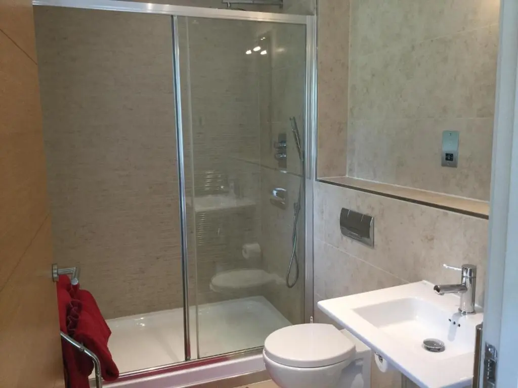 a bathroom with a shower and a toilet and a sink at Castlefield Apartment Free Parking in Inverness