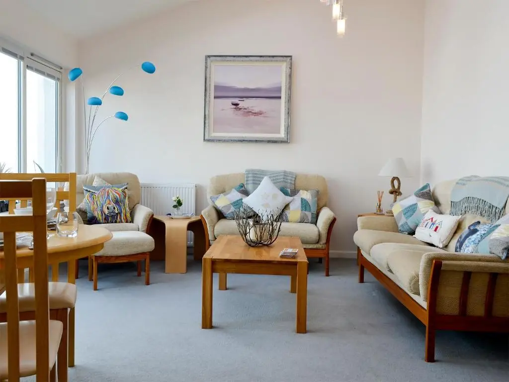 a living room with couches and a table at Seascape in Whitehills