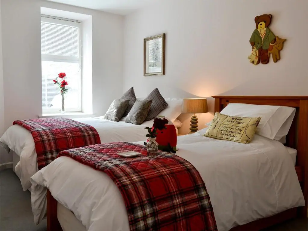 a bedroom with two beds with a stuffed animal sitting on top at Seascape in Whitehills