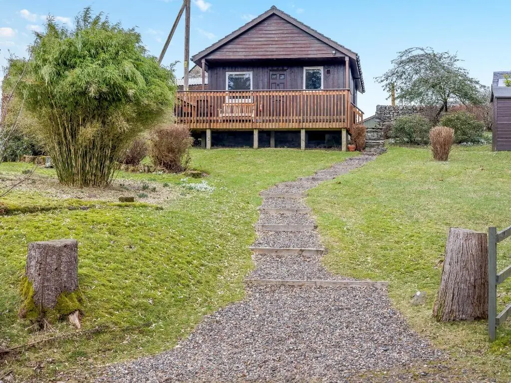 a stone path leading to a house with a deck at Boreland Farm Cabin - Uk5855 in Kirkmichael