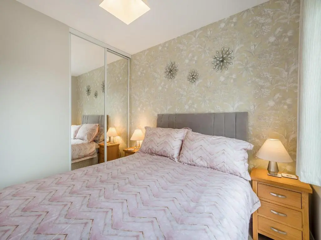 a bedroom with a large bed and a mirror at Boreland Farm Cabin - Uk5855 in Kirkmichael