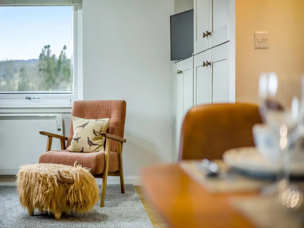 a living room with a chair and a table at Boreland Farm Cabin - Uk5855 in Kirkmichael