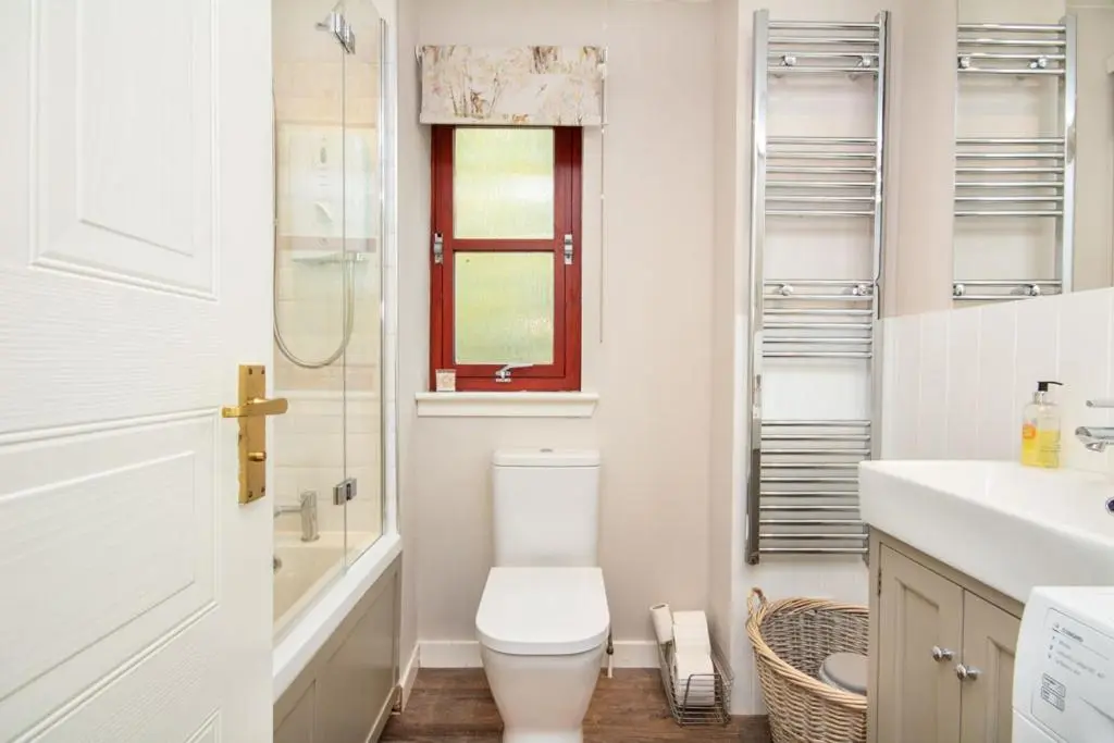 a bathroom with a toilet and a sink and a window at Aviemore Highlands No82 in Aviemore