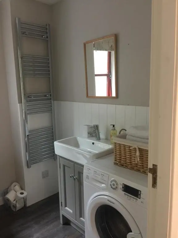a bathroom with a washing machine and a sink at Aviemore Highlands No82 in Aviemore