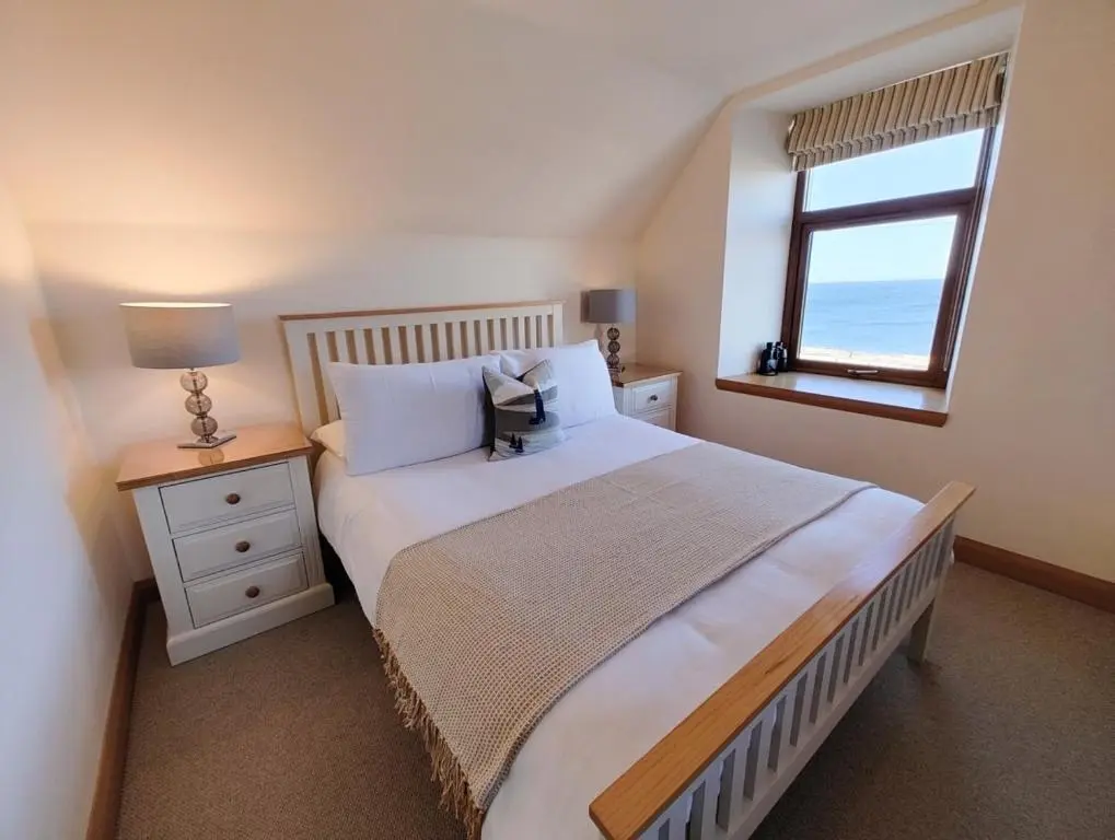 a bedroom with a large bed and a window at Portknockie 17 Harbour Place in Portknockie