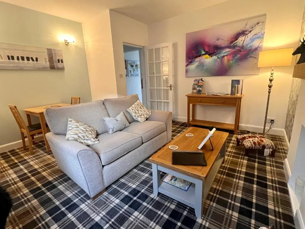 a living room with a couch and a coffee table at The Stags Head Apartment in Inverness