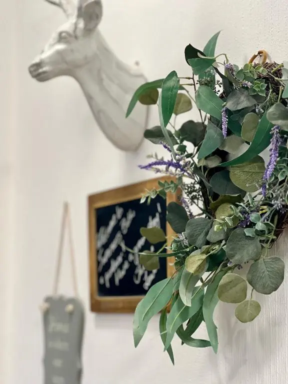 a picture of a deer head on a wall with a plant at The Stags Head Apartment in Inverness