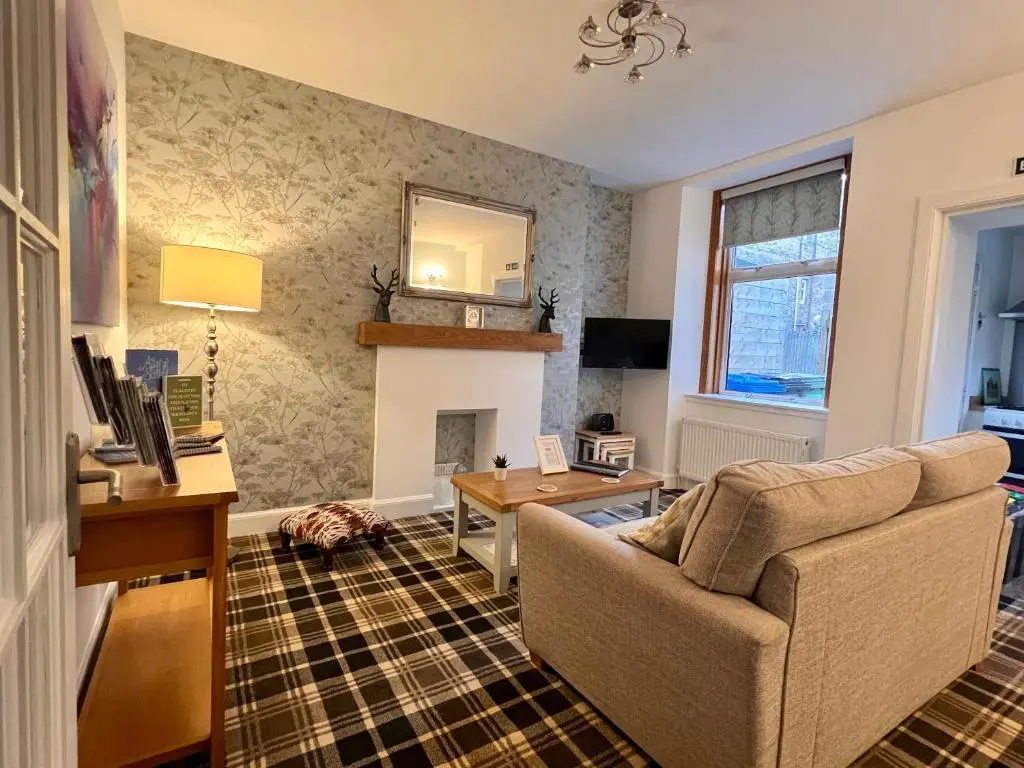a living room with a couch and a fireplace at The Stags Head Apartment in Inverness